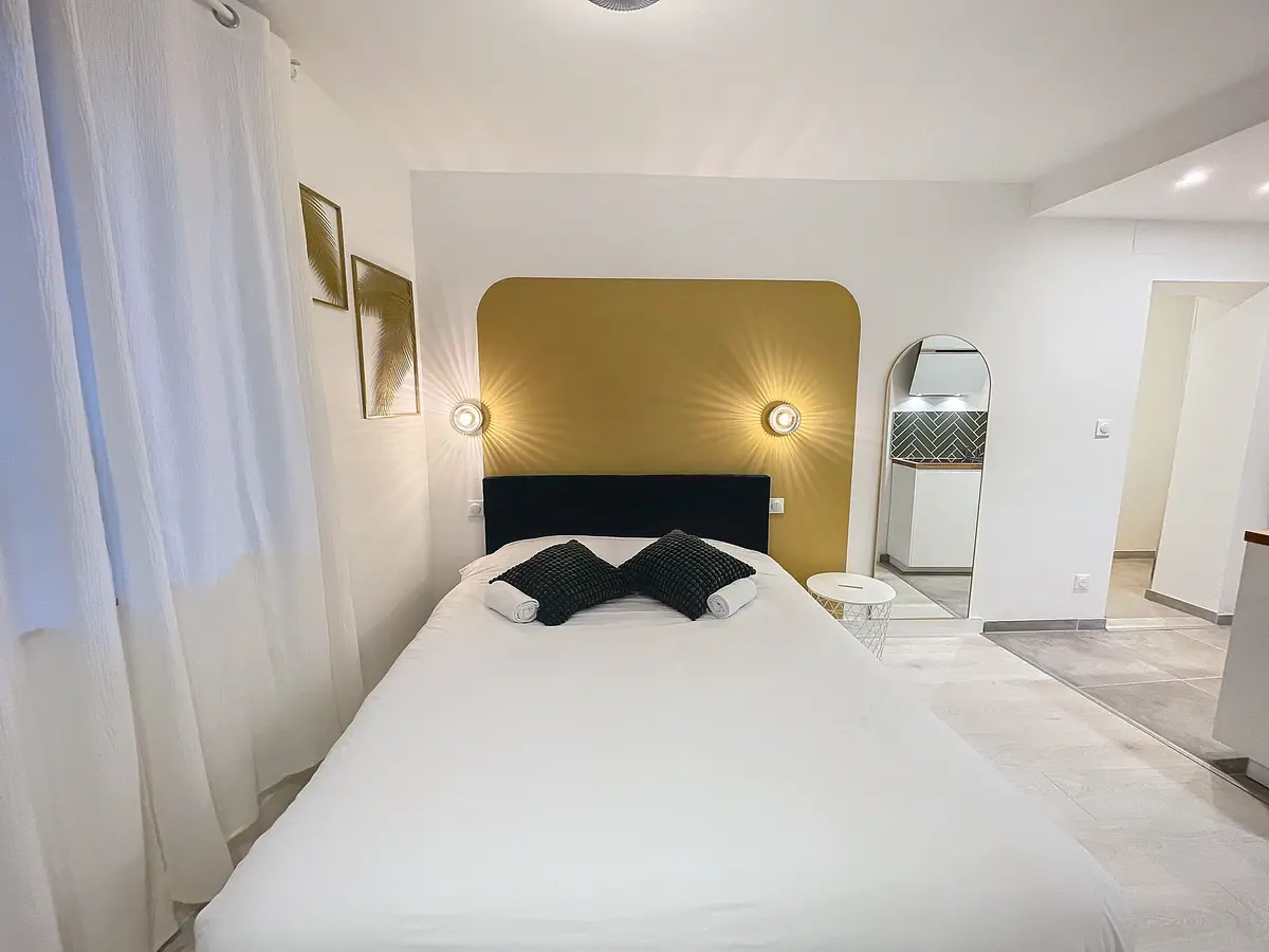 Studio La Canopée avec tête de lit jaune et décor végétal